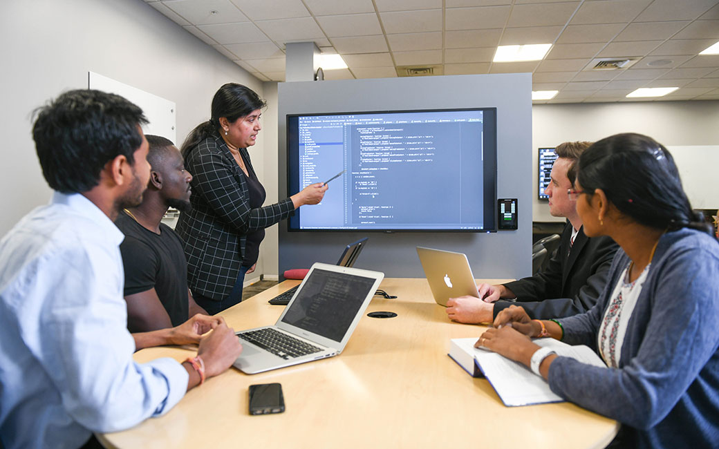 Students looking at screen with teacher instructing