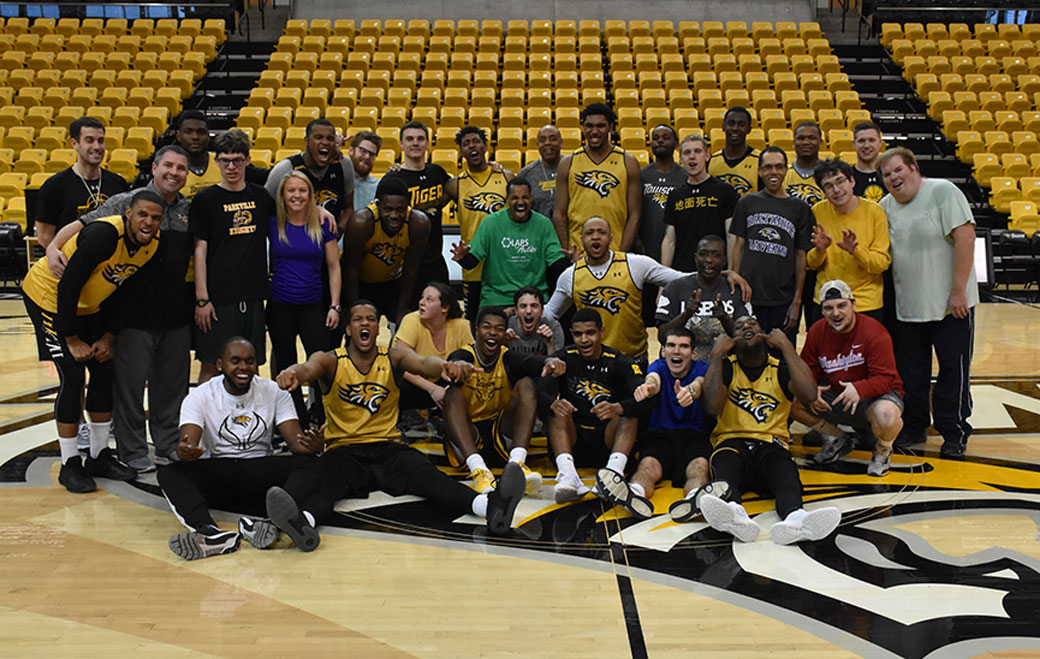 Members of the Towson University men's basketball team pose with members from the Hussman Center for Adults with Autism during a special clinic held at SECU Arena.  
