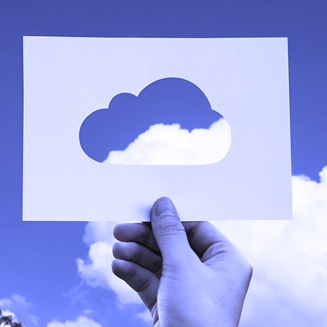 blue-tinted image of human hand holding a card with a cloud-shaped cut out
